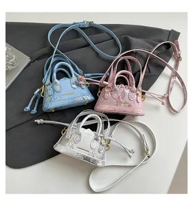 Detaillierte Ansicht von stilvollen Mini-Eimertaschen mit schickem Schlangenmuster.