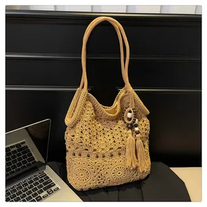 Detail of bohemian hollow knit tote bag with tassel charm and bead decorations