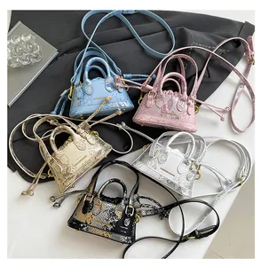 Draufsicht auf Mini-Beuteltaschen mit Schlangenmuster in Blau, Rosa und Gold