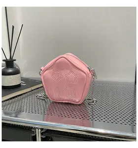 Detailed macro view of pink star-shaped crossbody bag with quilted patterns and silver chain