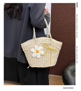 Détail du sac cabas en paille avec marguerite au crochet et ruban décoratif jaune vif
