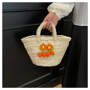 Detail of handmade woven straw bag with crochet orange flower charms and texture