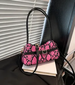 Dettaglio della borsa a spalla in pelle di serpente rosa con fibbie dorate