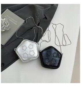 Close-up of star-shaped crossbody bags in silver and black with quilted faux leather texture