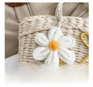 Gros plan détaillé du tissage en paille avec fleur au crochet blanche sur le sac beige