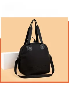 Detail of black large-capacity travel bag featuring woven handles and adjustable strap