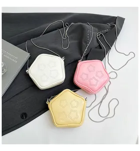 Detailed view of pentagonal chain bags in cream white, cherry pink, and soft yellow colors