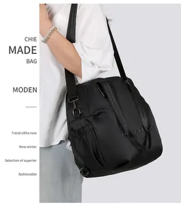 Detail of a large black nylon crossbody backpack featuring adjustable straps and side pockets
