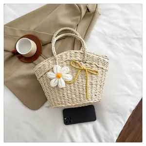 Détail d'un sac en paille avec marguerites au crochet et nœud jaune en décor décontracté
