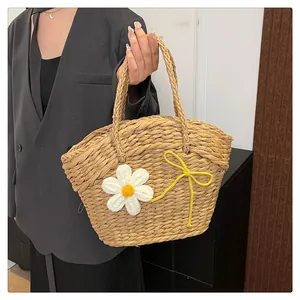 Gros plan du sac en paille tissé avec marguerites au crochet et nœud jaune décoratif