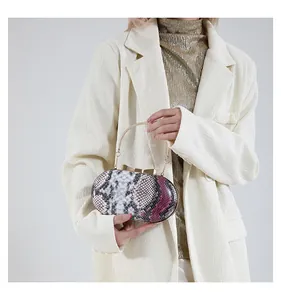 Detail of snake skin texture clutch with gold bow clasp and metallic handle