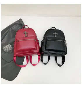 Detail of punk style backpacks with silver cross pendants and metal rivet decorations