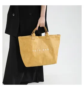 Detail of yellow DuPont paper tote bag with TOTE BAG print and textured finish