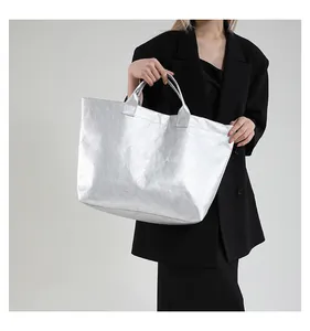 Detail of silver metallic tote bag with crinkled texture and letter print