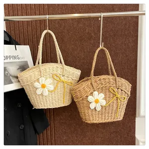 Détail de sacs fourre-tout en paille avec marguerites au crochet et anses tressées