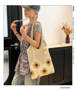 Detailed close-up of a handmade crochet tote bag with sunflower pattern and tulip pendant