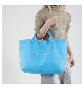 Close-up of textured blue DuPont paper tote bag with printed white TOTE BAG lettering