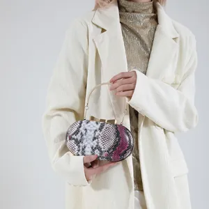 Snake skin pattern evening clutch with purple accents and gold butterfly bow handle