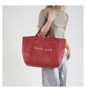 Detailed view of the red tote bag featuring a unique crinkled texture and TOTE BAG print