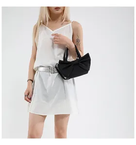 Λεπτομερής λήψη μαύρης υφασμάτινης τσάντας με σχέδιο φιόγκου και ρυθμιζόμενο λουράκι