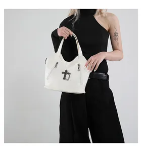 Detail of white gothic cross handbag with lychee pattern faux leather and metal zippers