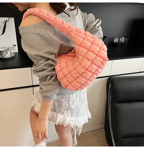 Detalle de bolso de hombro acolchado rosa con correa fruncida en modelo