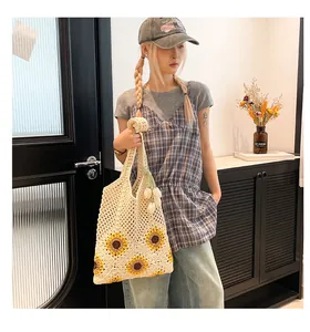 Detail of hand-woven crochet tote bag with vibrant yellow sunflower patterns and open mesh