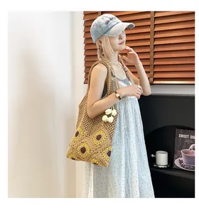 Close-up of handmade crochet straw tote bag featuring sunflower patterns and hollow mesh weave
