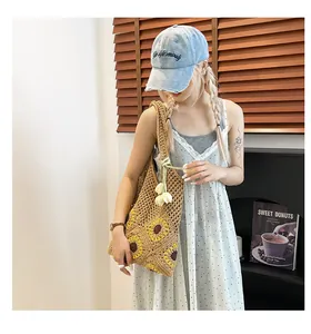 Detailed crochet shoulder bag featuring yellow sunflower patterns and a bohemian style