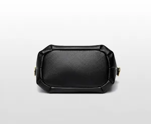 Gros plan du fond du sac en cuir noir grainé avec des détails métalliques dorés