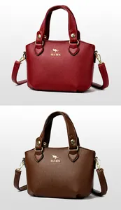 Détail de sacs à main en cuir grainé rouge et brun-jaune avec logo kangourou doré