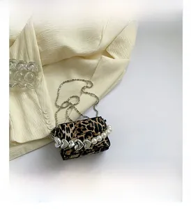 Detail of leopard print crossbody bag with silver heart studs and faux pearl handle