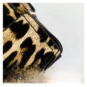 Macro shot of high-quality leopard print texture and fine stitching on a square bag
