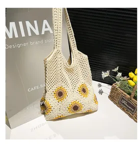 Close-up of handmade hollow straw tote bag featuring yellow sunflower crochet patterns