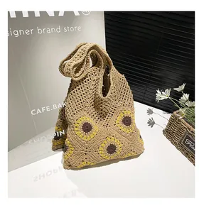 Detail of sunflower crochet pattern on a beige woven tote bag with hollow knit texture