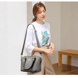 Sac à main élégant en similicuir gris avec bandoulière réglable sur un mannequin