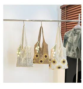 Detail of crochet tote bags with sunflower patterns and handmade tulip flower pendants