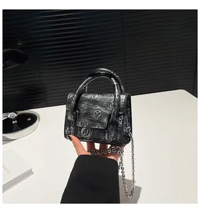 Close-up of silver skull pattern mini bag with metal chain strap and round handle