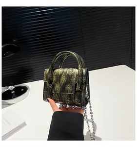 Detail of vintage embossed crossbody bag with metallic chain and radial pattern