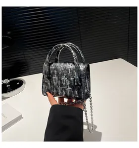 Close-up of gothic mini bag with 3D embossed crosses and vintage silver chain strap