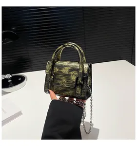 Detail showing the vintage metallic texture and embossed animal patterns on the mini bag