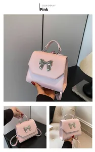 Detail view of pink PU leather handbag showing flap cover and silver bow accessory