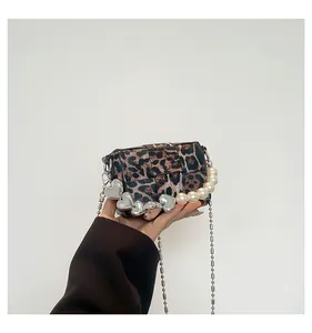 Detailed macro view of leopard print small square bag with pearl and heart charms