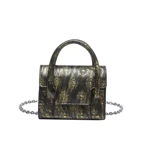 Gothic style mini crossbody bag with skull cross detail and silver chain strap