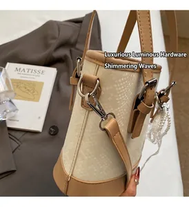 Detail der Schlangenhaut-Eimertasche mit Perlenanhänger und Lederbesatzdetails