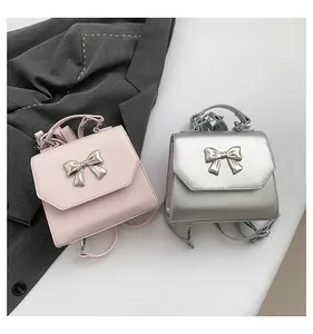 Detailed view of pink and silver mini handbags with metallic bow buckle and handle