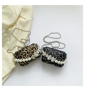 Detail of leopard print mini bag with pearl handle and silver heart charm chain