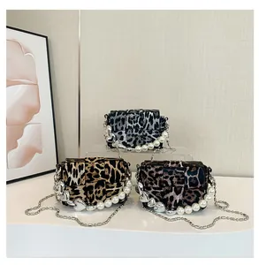 Detail of leopard print crossbody bags with pearl chain handles and heart charms