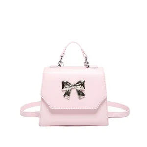 Pink faux leather mini square handbag with silver bow detail and dual shoulder straps