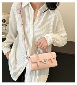 Chic pink crossbody bag with metal lock shown in a casual lifestyle setting